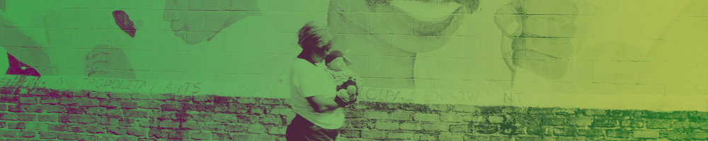 Image of a mother and child walking in front of a mural in New Orleans