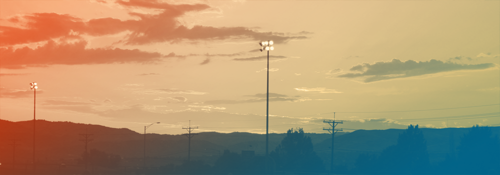 View of a sunset with athletic field floodlights in Denver, Colorado