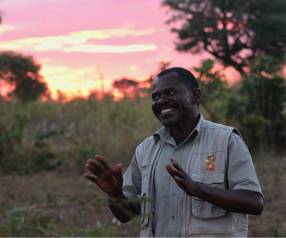 Photo of Winifred Mwale smiling broadly as the sun sets behind him