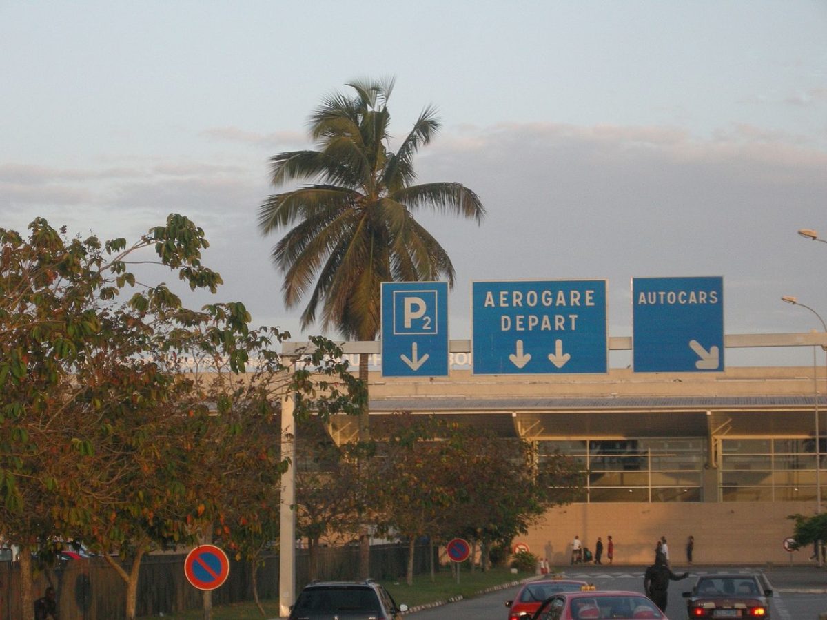 Photograph of palm tree signs reading "P2 / Aerogare Deaprt / Autocars" outside an airport terminal